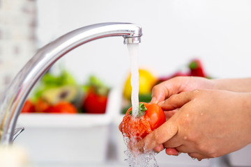 hand washing vegetables (tomatoes) with plenty of water