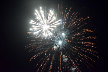 Festive salute in night sky. Explosions of fireworks and pyrotechnics in the sky.