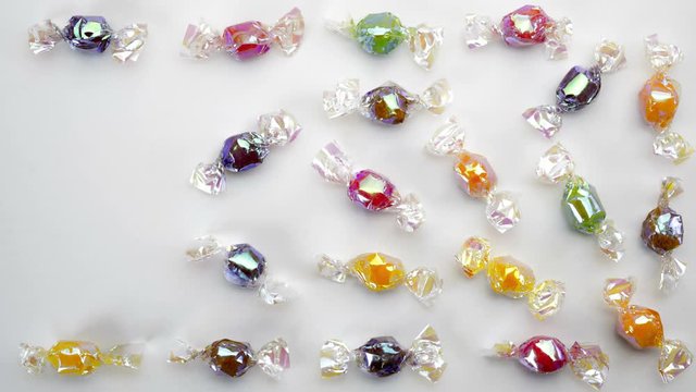 Multicolor candies on white background  stop motion animation 4k