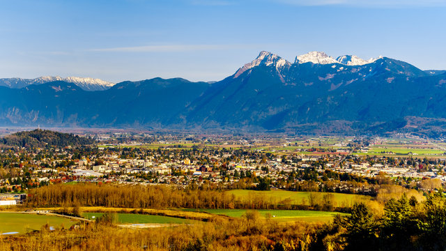 The sun setting over Cheam Peak, Lady Peak and Knight Peak in the Cascade Mountains and over the town of Chilliwack in the Fraser Valley of British Columbia, Canada