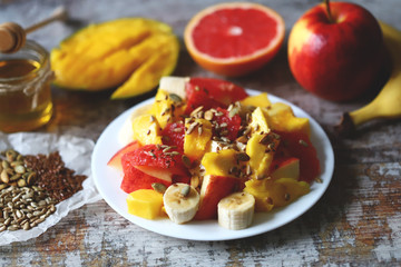 Selective focus. Super fresh nutritious fruit salad with seeds. Salad with mango, banana and grapefruit. Vitamin food. Healthy food.