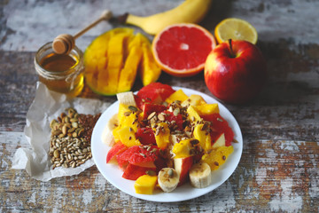 Selective focus. Super fresh nutritious fruit salad with seeds. Salad with mango, banana and grapefruit. Vitamin food. Healthy food.