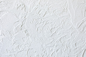 The background of the raised white wall is finished with decorative plaster. Abstract streaks like waves on a concrete wall. Design renovation of old housing and commercial real estate