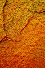 Bright old painted wall with destroyed plaster. Grungy background with cracks, chips and other irregularities.