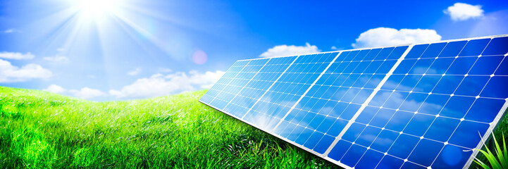 Solar Panels In Green Grass Landscape With Blue Sky And Sunlight - Clean Energy Concept