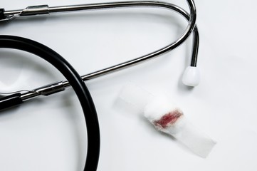 Blood on cotton wool and white plaster on white background with Stethoscope. Blood Donation Morphology vaccines concept.