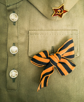 Holiday of 9 May Victory day 1945 vertical background. Soviet army military uniform of tunic, forage cap, St. George ribbon. Flat lay, layout, top view, copy space.
