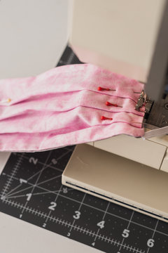 pink fabric with pins in a sewing machine