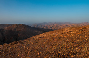 Fototapeta na wymiar Panoramic view at volcanic landscape nearby Pajara on canary island Fuerteventura. Sunset in october 2019