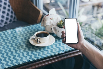 cell phone Mockup image blank white screen.man hand holding texting using mobile on desk at coffee shop.background empty space for advertise text.people contact marketing business,technology
