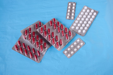 Still life : tablets white and red in plates on a blue background