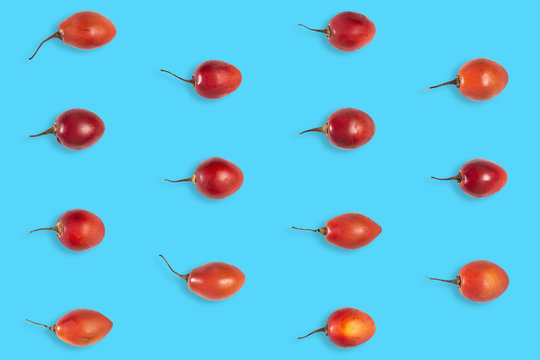Fruit pattern of raw tomarillo or tomate de &aacute;rbol on blue background from top view