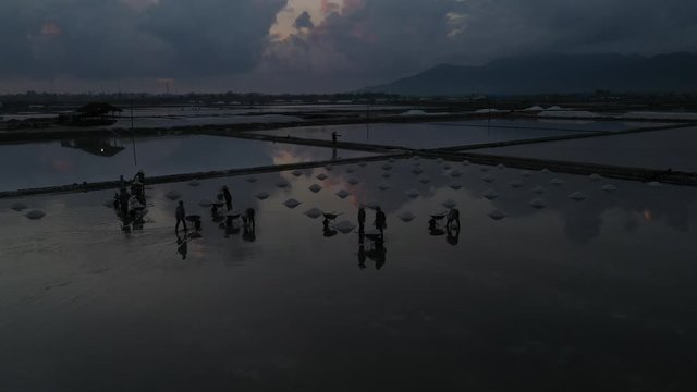 People working on Hon Khoi salt field, Khanh Hoa, Vietna. The raw white salt field on a sunny day. Free stock video footage of white salt field in a beach village. Salt is an important food for people