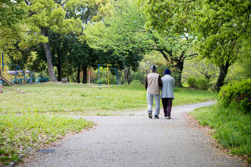 朝の公園で散歩しているシニア夫婦