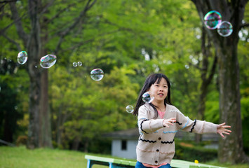 公園でしゃぼん玉を遊んでいる子供