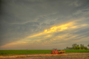 Fototapeta premium Vintage farm trucks with an impending summertime storm