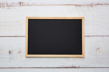 blackboard with a wooden frame on a wooden background