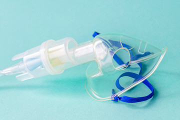 Transparent mask from an inhaler on a blue background. The device for inhalation of therapeutic steam.