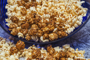 sweet and salty popcorn in a glass bowl on an abstract background