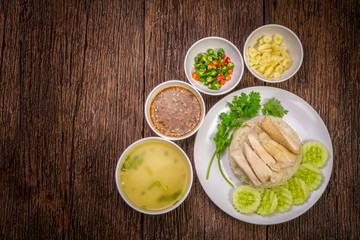 Steamed chicken rice with chicken soup, Hainanese chicken rice on a wooden background,