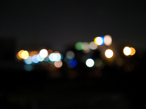 Blurred and soft focus of colorful circle bokeh lights on black background. © kittima