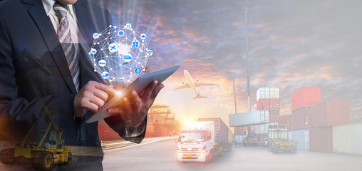 Multiple exposures of Businessman touching tablet for analyze stock at logistics port and world map with logistic network distribution on background, transportation trading business concept,