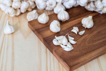 Closeup of garlic cloves on a wooden cutting Board with garlics blur background.