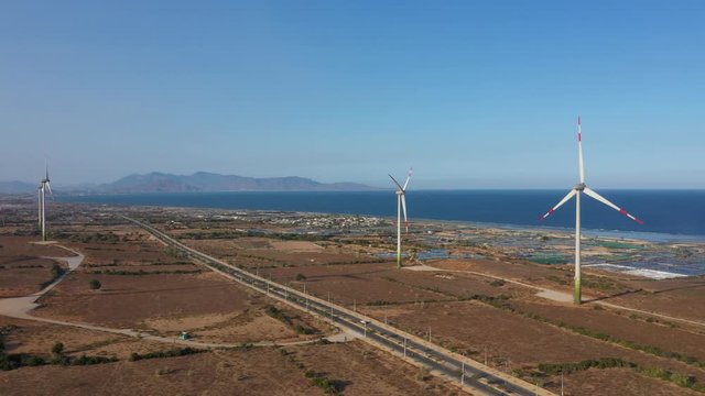 Aerial view of windmills farm for energy production on rice field, Mui Dinh, Ninh Thuan, Vietnam. Wind power turbines generating clean renewable energy for sustainable development