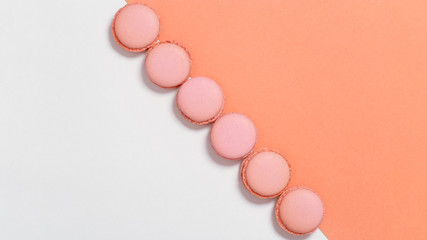Tasty orange macaroons. Minimal style image with row of almond cookies. Food background, flat lay, copy space.