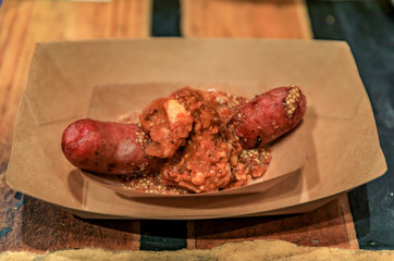 Traditional Polish beef and pork kielbasa, topped with bourbon bacon relish and mustard, served on a paper plate
