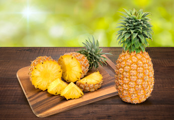 Fresh pineapple on the brown wooden table in garden, Fresh pineapple fruit. Pineapple fresh fruit on wooden table in blur background.
