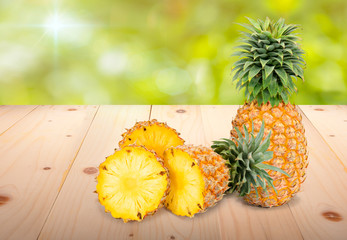 Fresh pineapple on the brown wooden table in garden, Fresh pineapple fruit. Pineapple fresh fruit on wooden table in blur background.