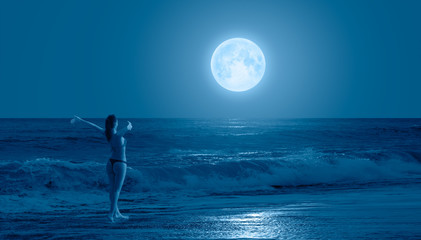 Night sky with moon in the clouds on the foreground power sea wave - Happy slim girl in red and...