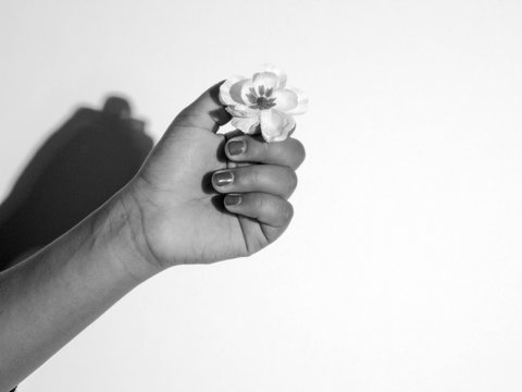 Cropped Image Of Hand Holding Ring Over White Background