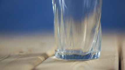glass on a wooden table. Blue background
