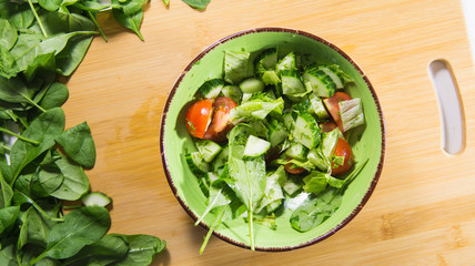 pours a fresh salad of greens and vegetables with sunflower oil. Healthy eating