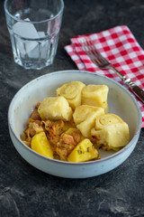 German dumplings or Strudel or Dampfnudel with sauerkraut, potatoes and pork meat. Festive meal of german , who comes from russia. Natural light, selective focus.
