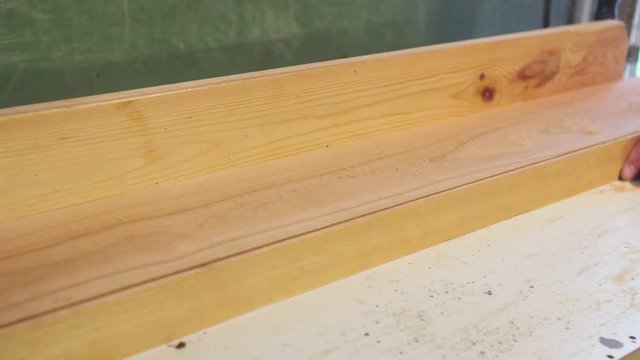 Carpenter works on circular saw, woodworking machine in the carpentry workshop .