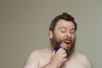 man grooming his beard carefully with scissors
