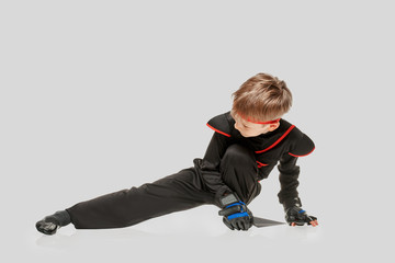 Young ninja boy practicing self-defense technigue with throwing knife