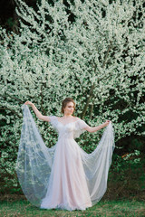 Obraz na płótnie Canvas Young beautiful woman in blooming garden. Bride.