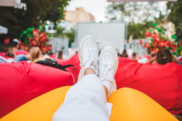 people at city public park watching movie at open air cinema