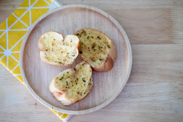 Wooden plate with delicious homemade garlic bread