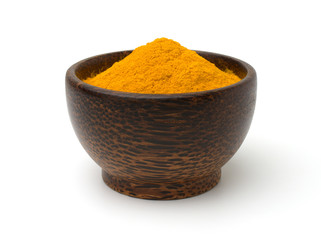 Turmeric (curcumin)  powder in a black wooden bowl  isolated on a white background.	