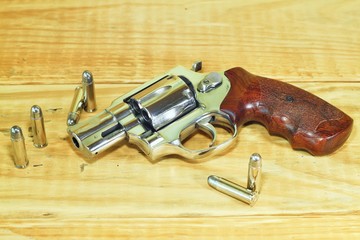 Revolver gun 38 mm size on wood background.
