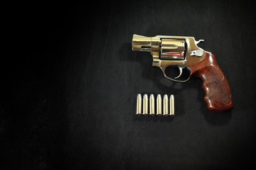 Revolver gun and Bullet 38 mm size on black fabric background.