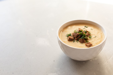 Tomato soup in a black bowl on grey stone background. Top view. Copy space.