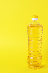 Plastic bottle with vegetable oil on a yellow background. Copy space.