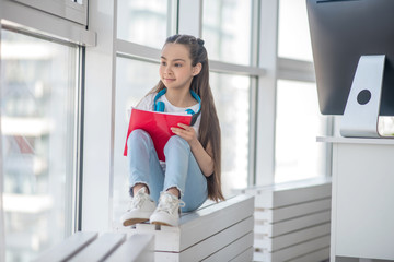 Long-haired girl in white tshirt looking thoughtful