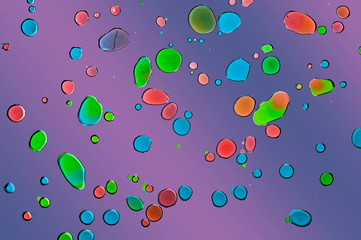 Colorful water drops on oil sheet with gradual background